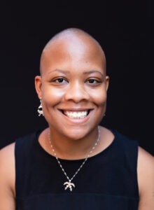 A headshot of Kee Merriweather smiling against