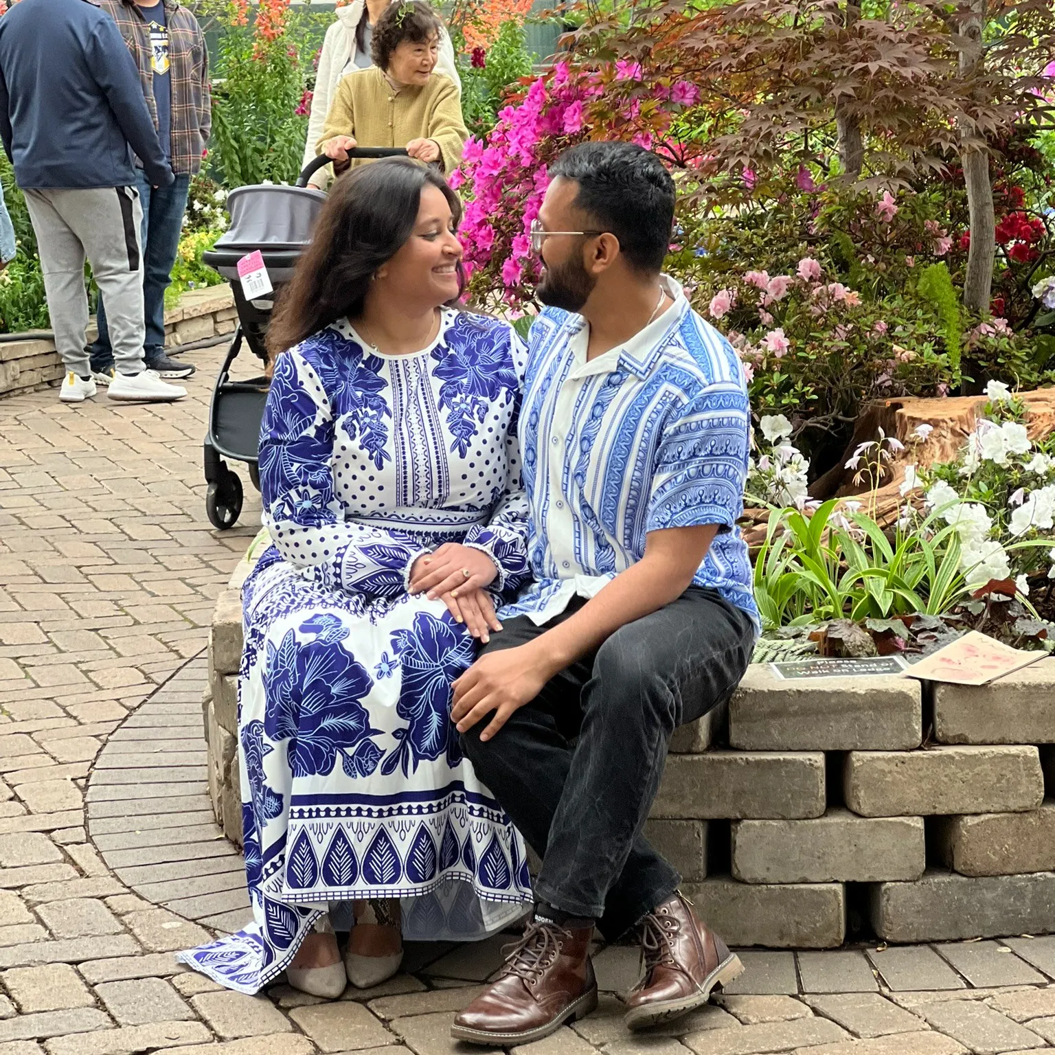 A couple sitting in front of flower