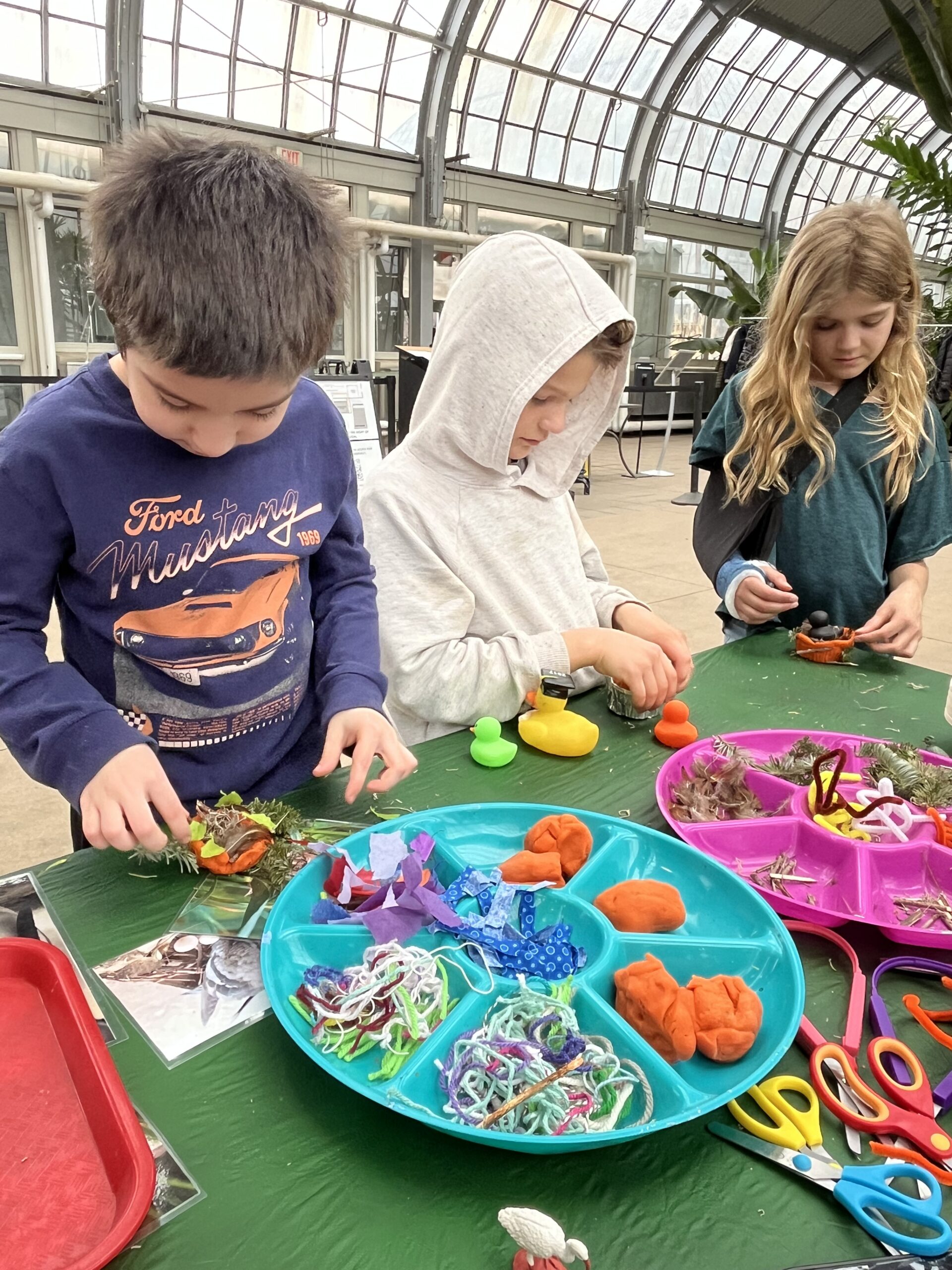 Children at a table with an assortment of supplies to play with.