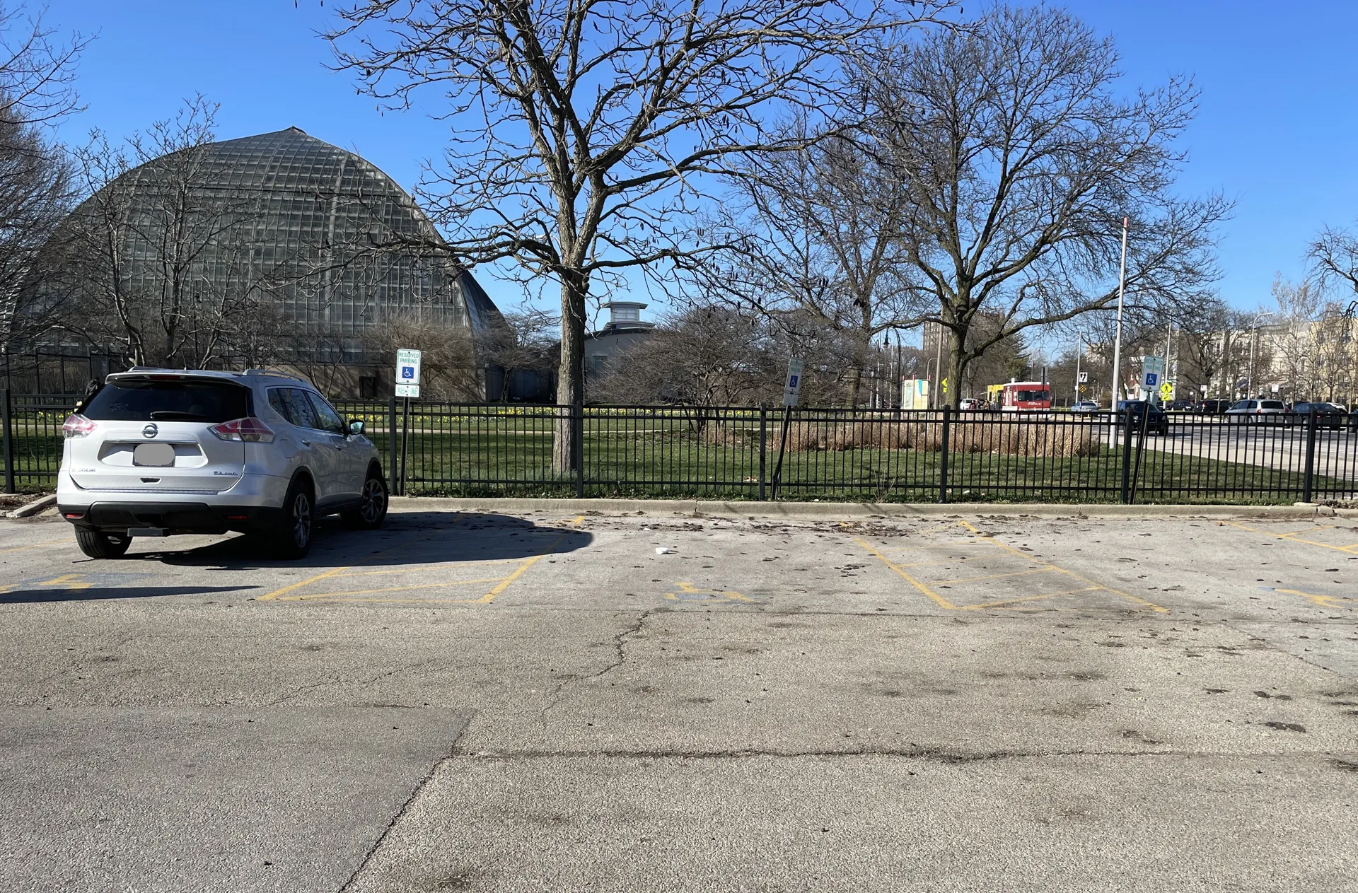 View from the visitor parking lot with a car in the accessible parking spot in the foreground.