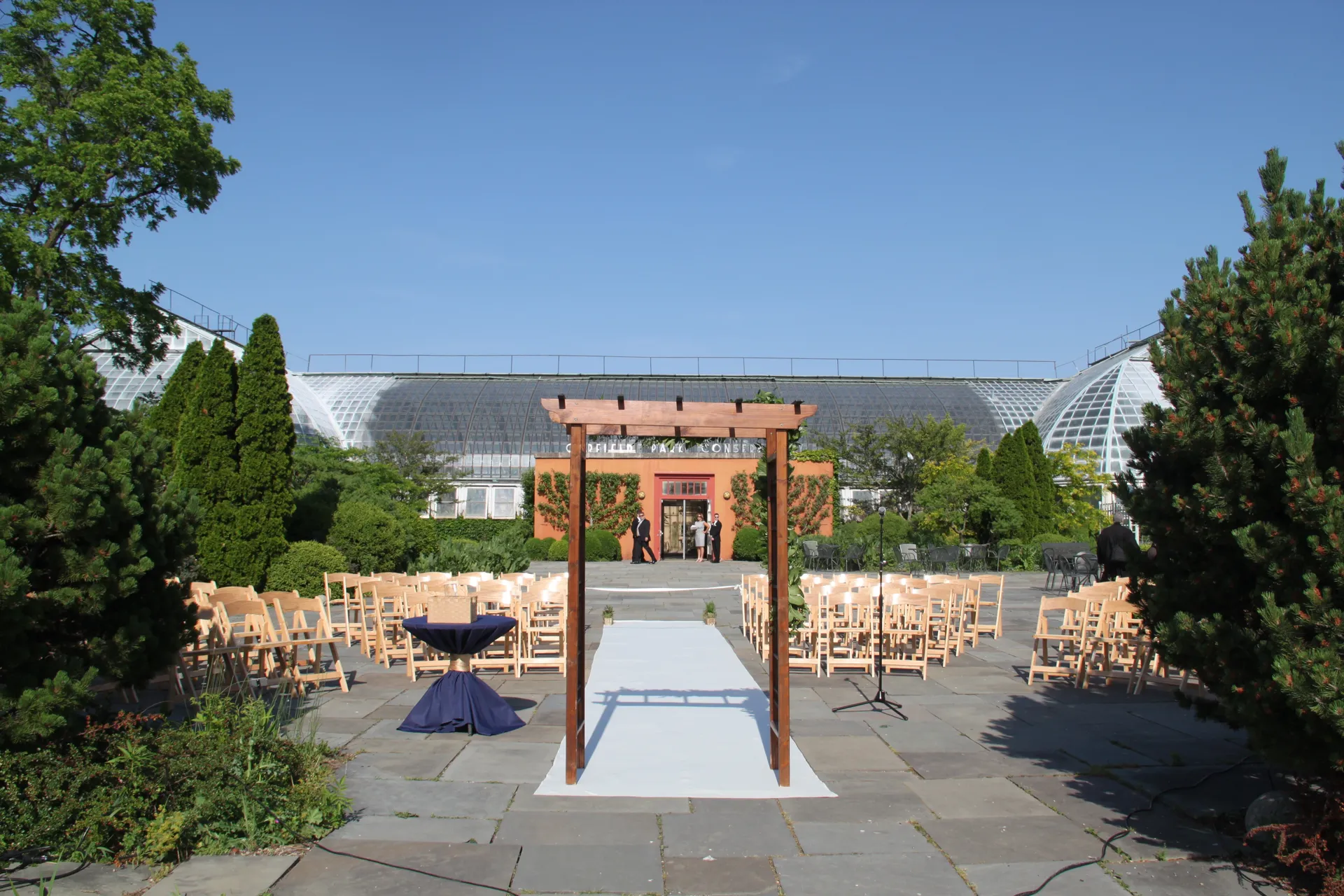 Outdoor ceremony set up on bluestone terrace with the alter in the foreground and Conservatory in the background.
